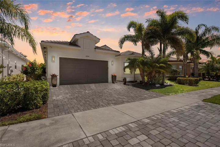 Mediterranean / spanish-style house featuring a tile roof, decorative driveway, stucco siding, and an attached garage