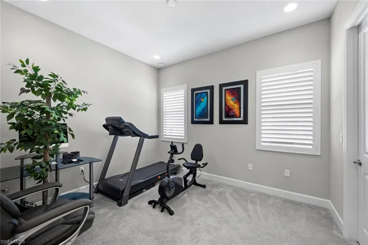 Exercise room with baseboards, recessed lighting, and carpet