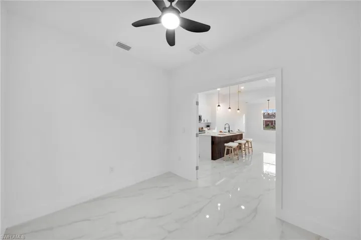 Spare room featuring sink and ceiling fan with notable chandelier