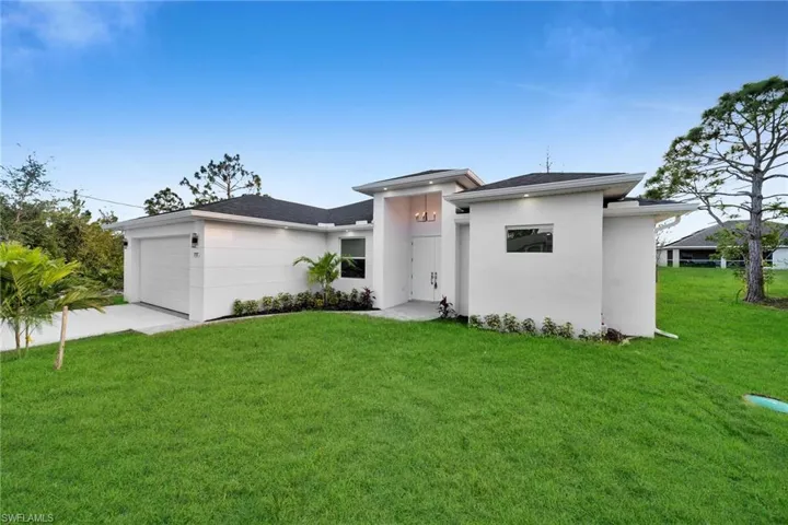 View of front of home featuring a garage and a front lawn