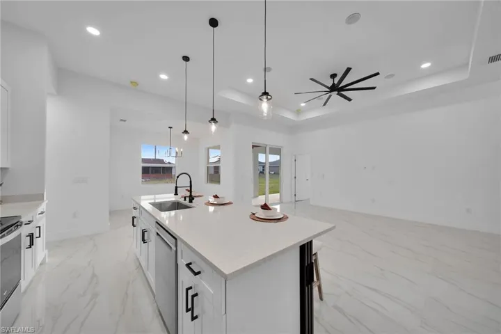 Virtually Staging Kitchen featuring a raised ceiling, white cabinets, appliances with stainless steel finishes, and sink