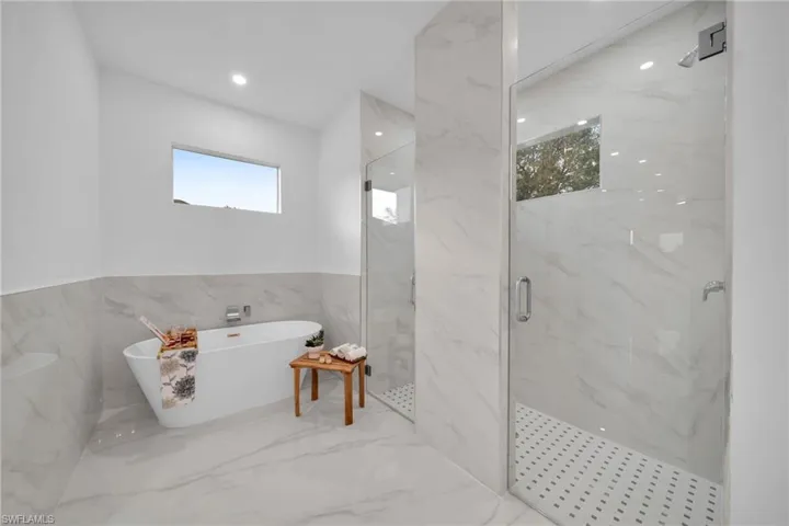 Bathroom featuring tile walls and independent shower and bath