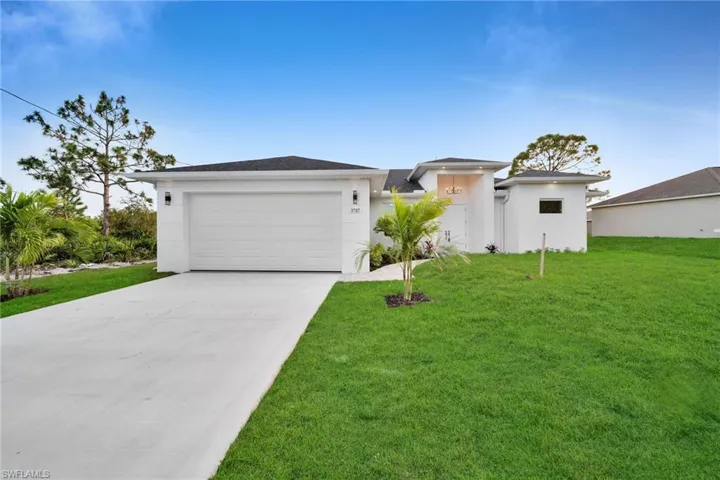 View of front of home with a garage and a front yard