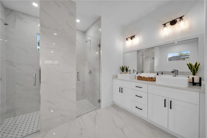 Bathroom with a shower with shower door and vanity