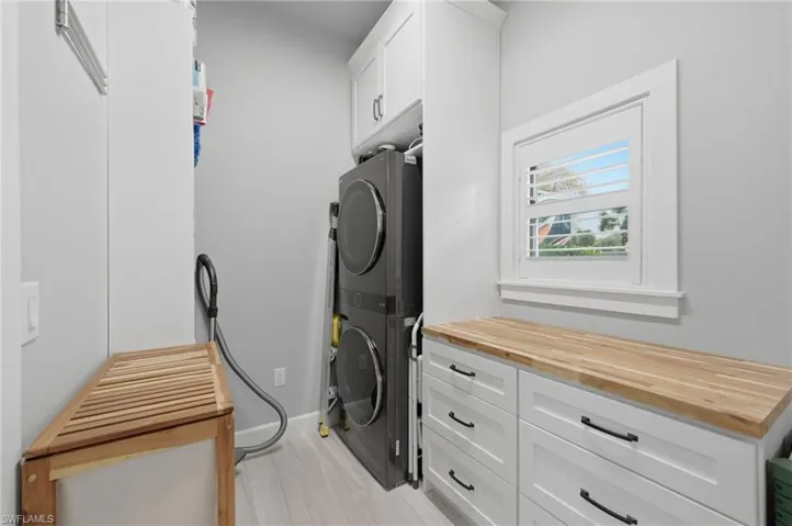 Laundry room featuring stacked washer / drying machine and cabinet space