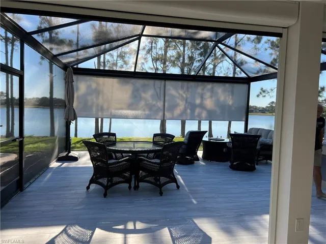 Sunroom / solarium with a water view, outdoor dining space, and healthy amount of natural light