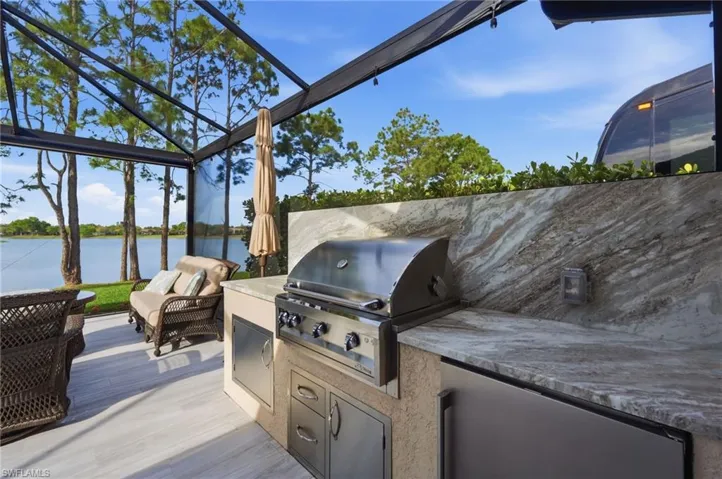 View of patio / terrace featuring exterior kitchen, a water view, and a sunroom