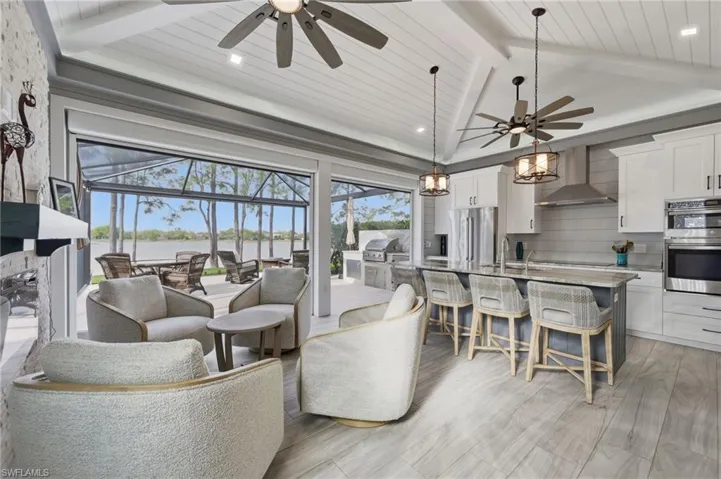 Living area with a ceiling fan, a wooden ceiling with exposed beams, light wood-style floors, a sunroom, and recessed lighting