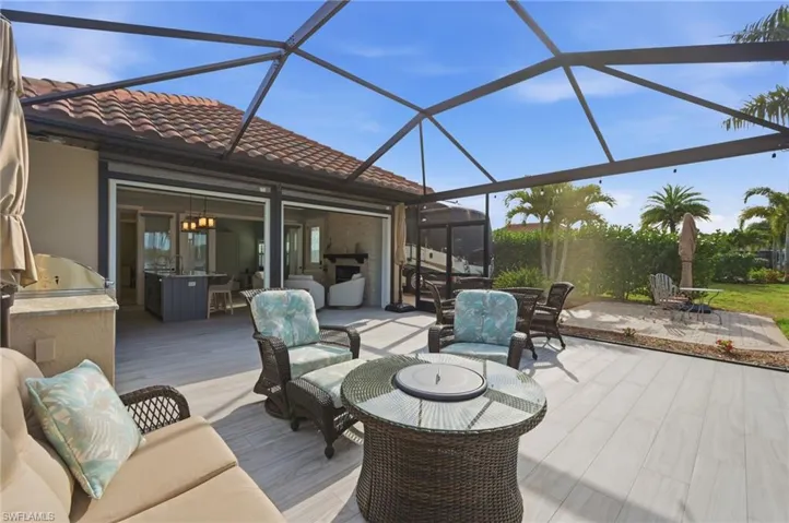 Deck with a sunroom, a lanai, a patio, area for grilling, and an outdoor living / dining area