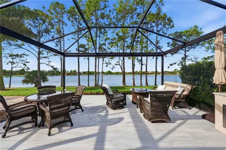 View of patio with a water view, an outdoor living / dining area, a sunroom, and glass enclosure