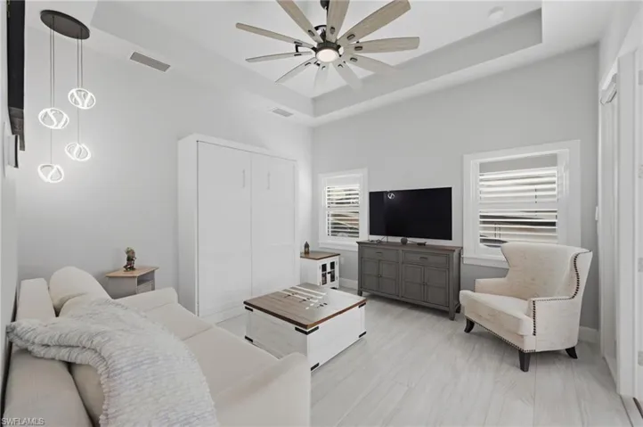 Living room with a tray ceiling and a ceiling fan