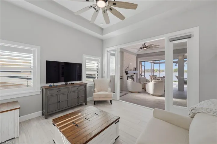 Living room featuring ceiling fan and a tray ceiling