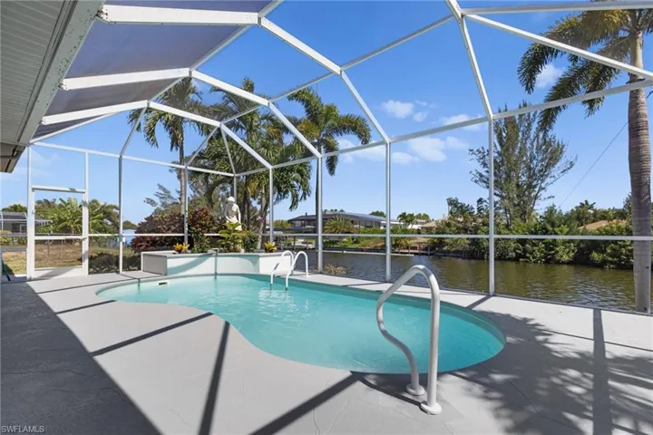 View of swimming pool featuring a patio, a lanai, and a water view