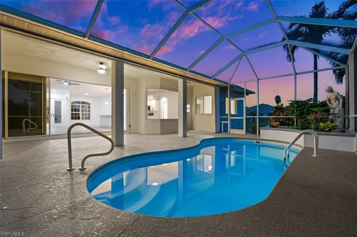 Pool at dusk with a lanai, a patio area, and ceiling fan
