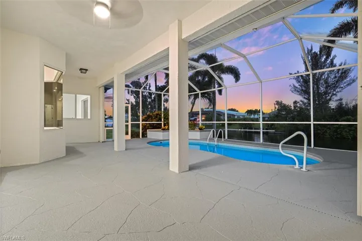 Pool at dusk featuring a patio and a lanai