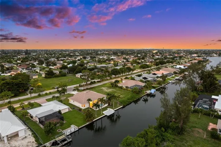 Aerial view at dusk featuring a water view