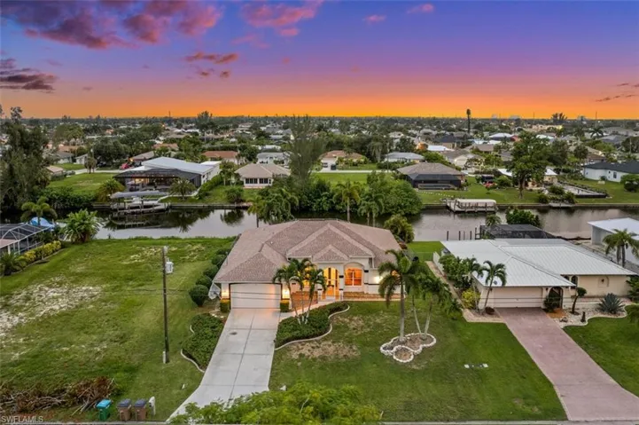 Aerial view at dusk featuring a water view