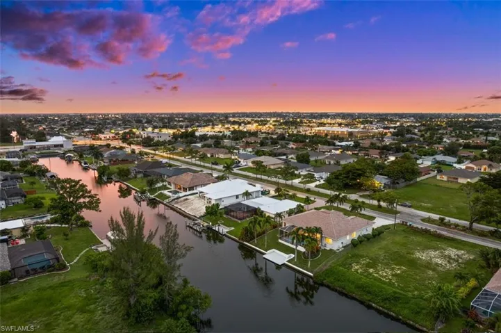 Aerial view at dusk featuring a water view
