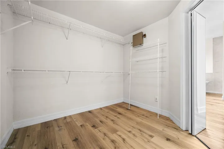 Spacious closet with light hardwood / wood-style flooring