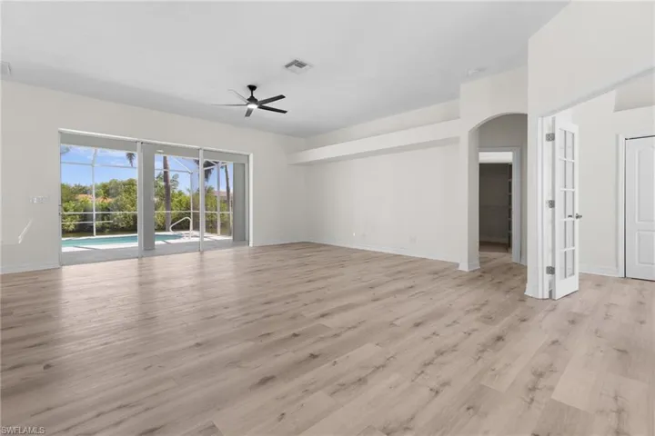 Empty room with ceiling fan and light hardwood / wood-style flooring