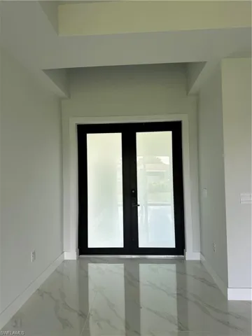 Empty room featuring tile patterned floors and french doors