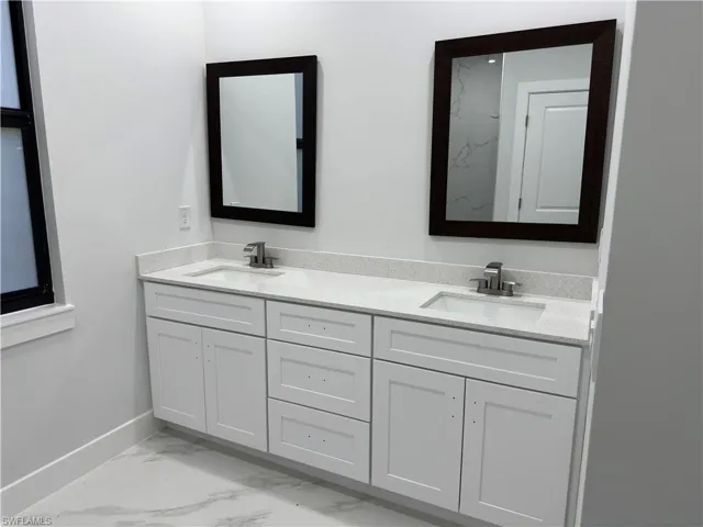 Bathroom featuring tile patterned flooring and double sink vanity