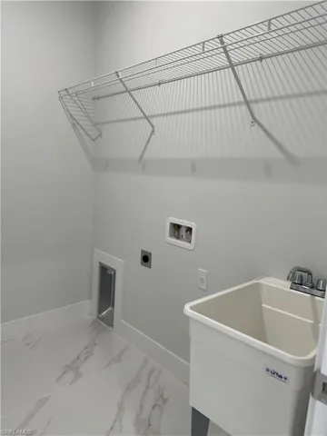 Laundry area featuring tile patterned floors, sink, hookup for an electric dryer, and hookup for a washing machine