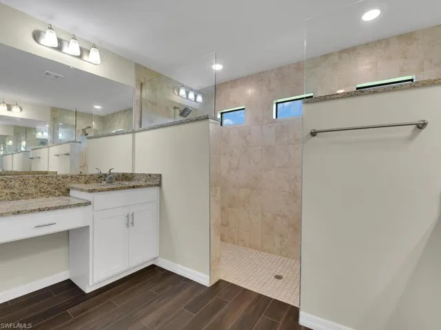 Bathroom with tiled shower and vanity