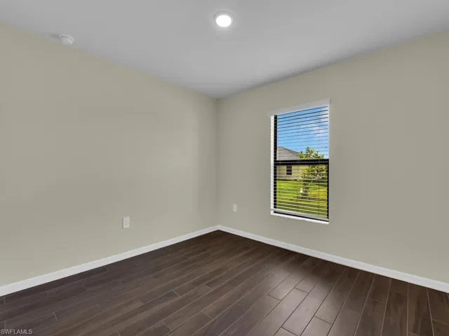 Empty room featuring dark hardwood / wood-style flooring