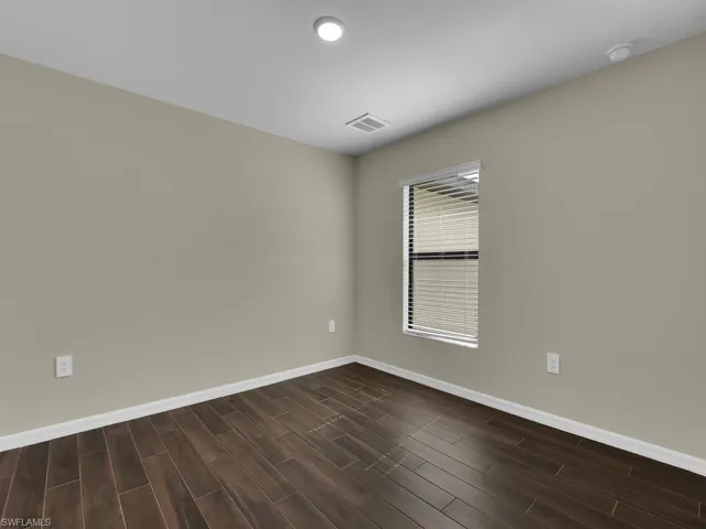 Empty room with dark hardwood / wood-style floors