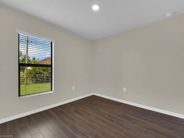 Spare room with dark wood-type flooring