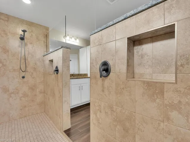 Bathroom with vanity and a tile shower