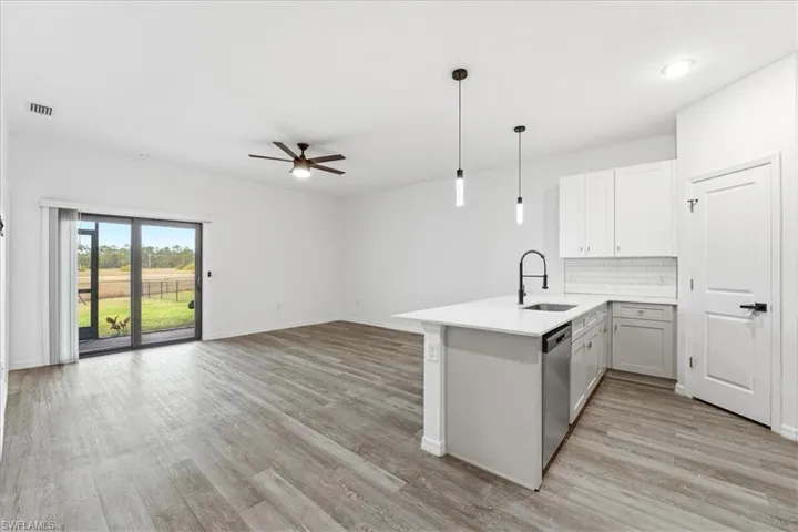 Kitchen with a peninsula, hanging light fixtures, tasteful backsplash, open floor plan, and a ceiling fan