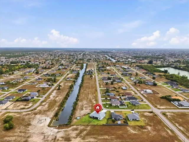 Aerial view of property's location featuring a nearby body of water and nearby suburban area