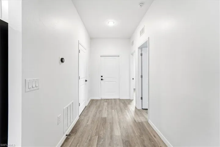 Hallway with light wood-style flooring and baseboards