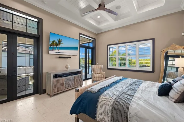 Master Bedroom featuring beam ceiling, ceiling fan, double french doors leading out to the pool & lanai, coffered ceiling with shiplap wood ceiling and plantation shutters