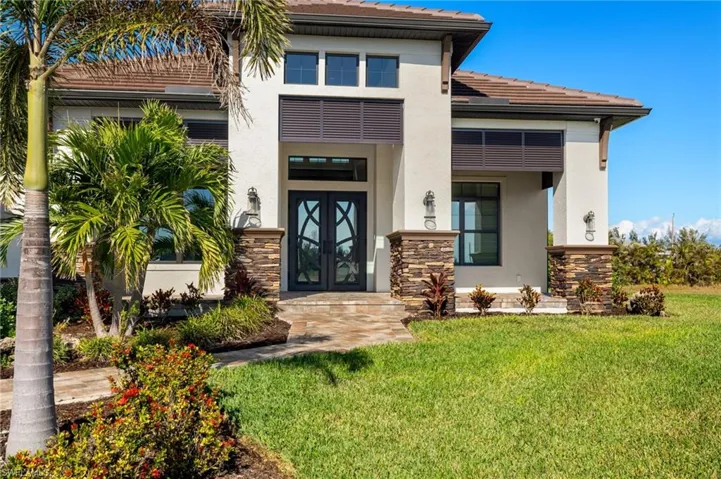 Entrance to property featuring french doors and a lawn