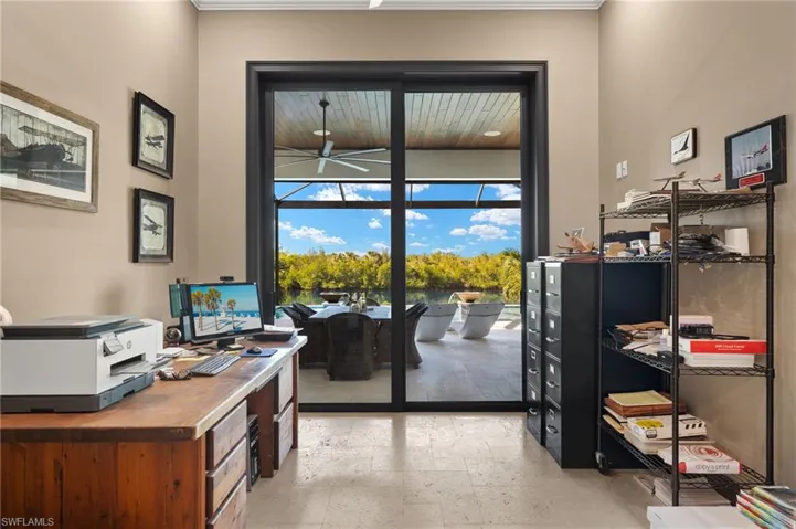 Rather large Den or Study with coffered wood ceilings with a beautiful view out to the pool, lanai, and canal.