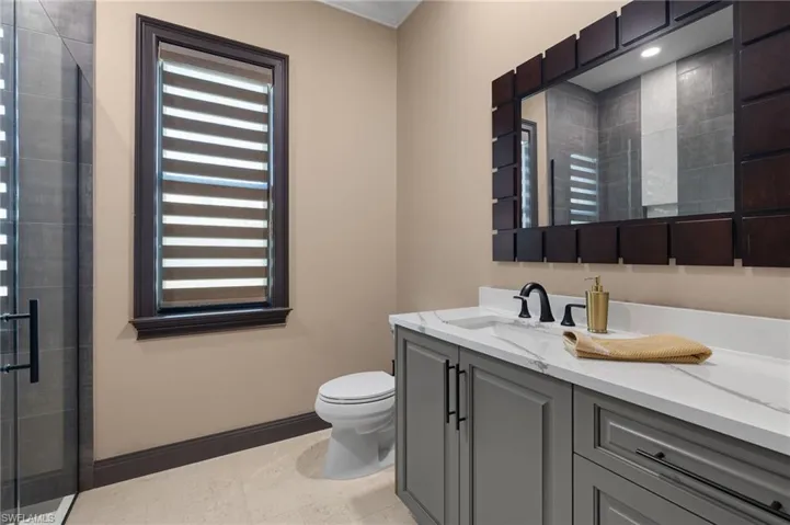 Bathroom #2 featuring Tavertine Tile Floors, quartz countertop and a glass shower enclosure