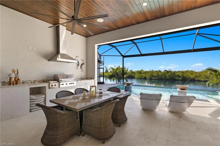 View of patio from the great room featuring a water view, area for grilling, and a covered lanai