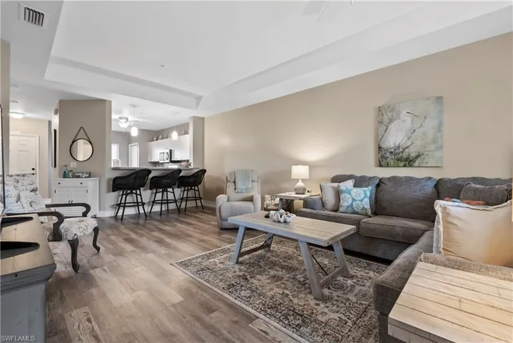 Living room with ceiling fan and hardwood / wood-style floors