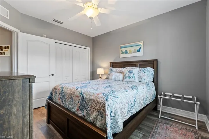 Guest Bedroom featuring ceiling fan, a closet, and dark wood-type flooring