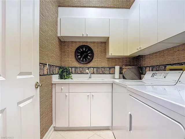 Laundry area featuring cabinet space, washing machine and clothes dryer, and light tile patterned floors
