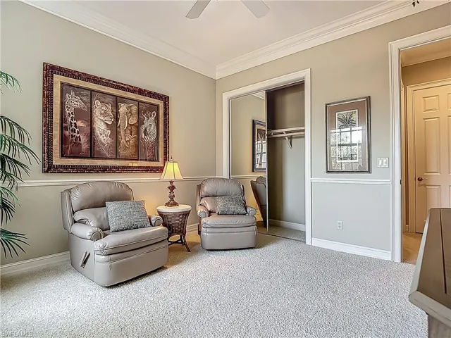Sitting room featuring carpet, crown molding, a ceiling fan, and baseboards