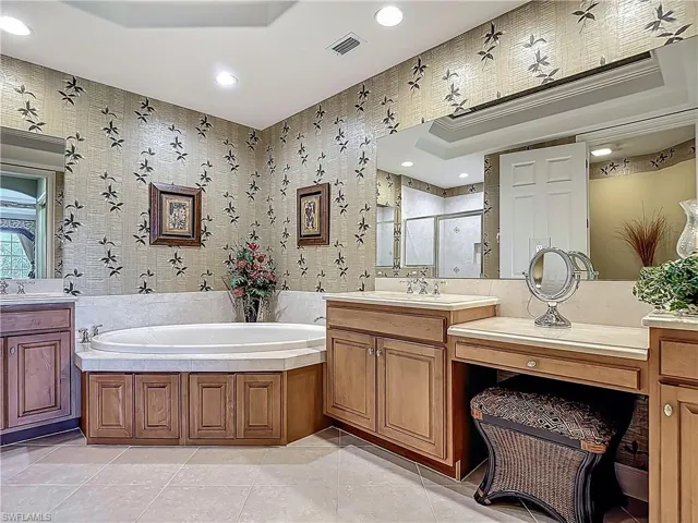 Bathroom featuring a stall shower, a garden tub, recessed lighting, tile patterned flooring, and vanity