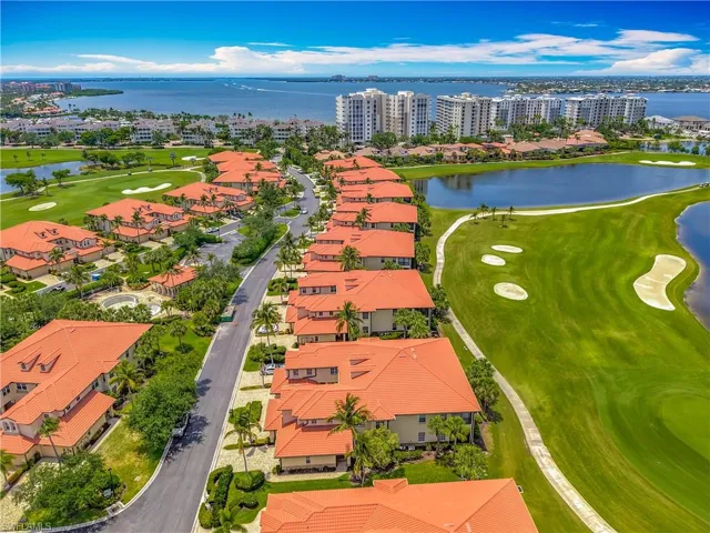 Aerial view of a local golf course, a large body of water, and apartment complex / building