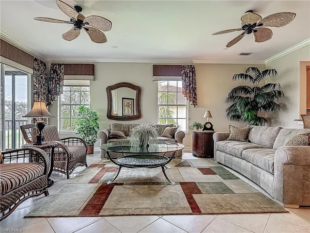 Tiled living room featuring ceiling fan and crown molding