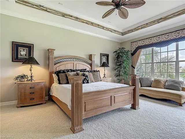 Bedroom featuring light carpet, crown molding, ceiling fan, and baseboards