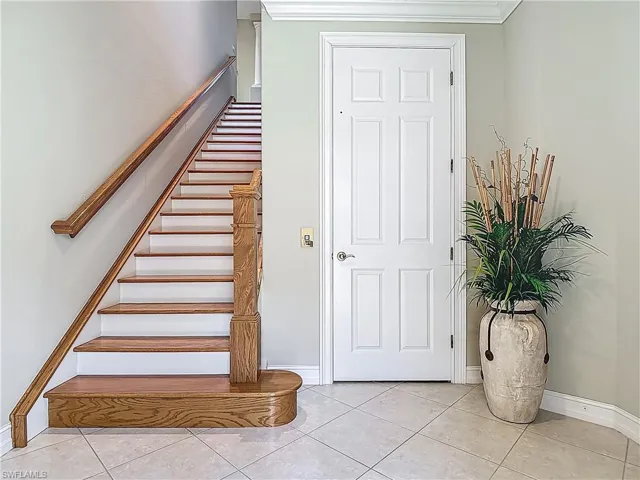 Stairway with baseboards and tile patterned floors