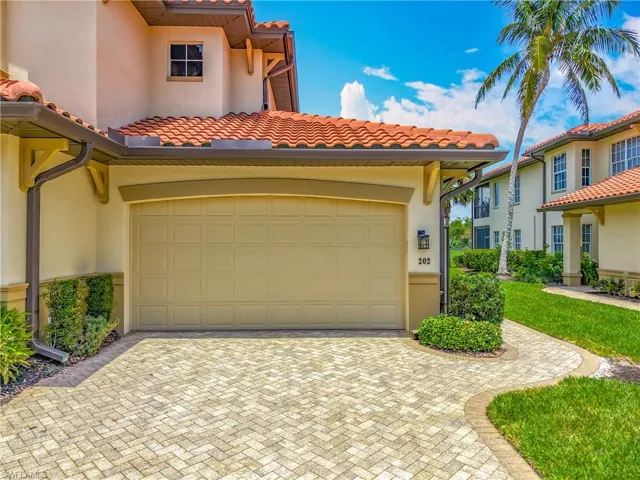 View of front of home featuring a tiled roof, stucco siding, and decorative driveway